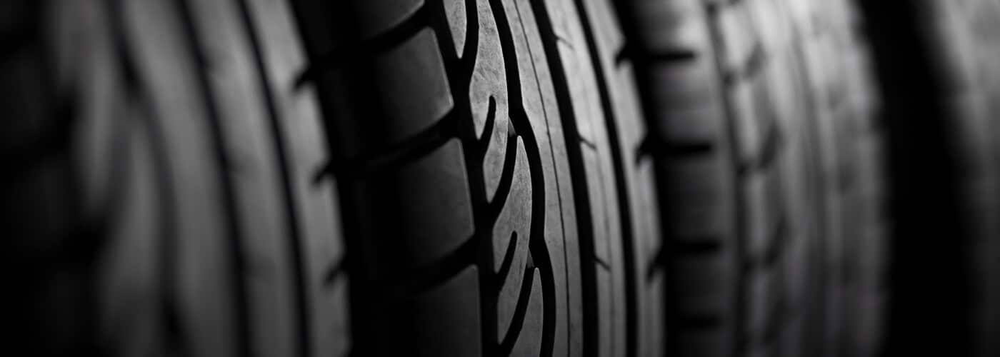 Close-up of tire treads in black and white, highlighting detailed patterns and textures.